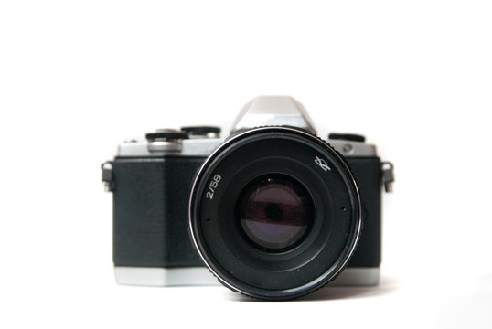 Retro camera with metal lens on white background