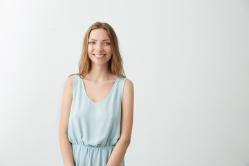 Portrait of young beautiful pretty girl smiling looking at camera over white background.