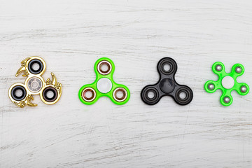 4 popular fidget spinners on White wooden background;