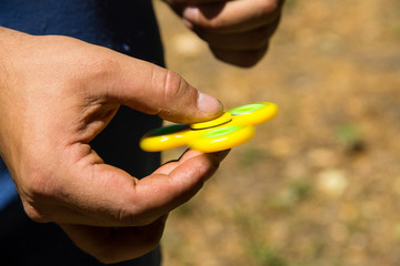 Man playing with fidget spinner stress relieving toy outdoor