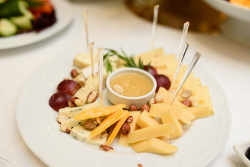 A dish of cheese, honey and nuts.