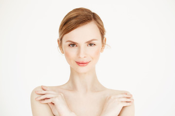 Portrait of young naked beautiful girl with healthy clean skin smiling looking at camera over white background. Cosmetology and beauty concept.