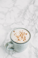 Cappuccino in a rustic style mug on a marble table