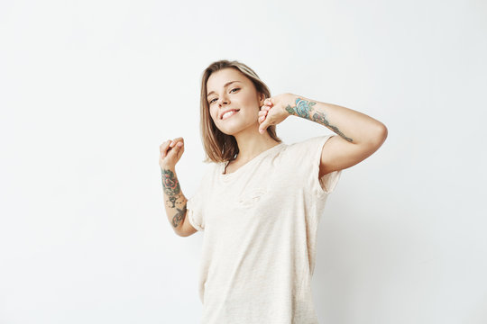Portrait of young beautiful tattooed girl smiling posing looking at camera over white background.