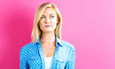 Portrait of a young woman standing against a solid background