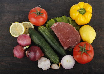 meat with vegetables on wooden background