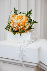 classical wedding bouquet from orange and white roses in a white interior. Tenderness, love, wedding concept.