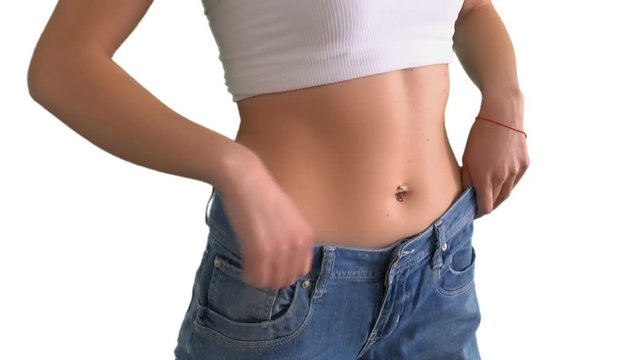 The girl shows that she has lost weight and jeans at the waist are wide, on White background