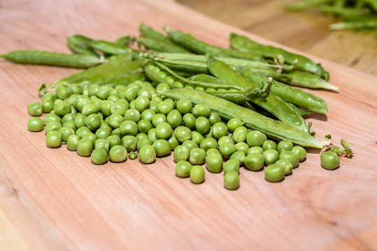 Fresh peas on a wooden board