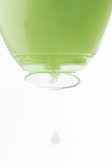 Cosmetic liquid pouring from bottle isolated on white background