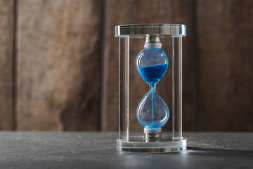 Time is passing. Blue hourglass close up