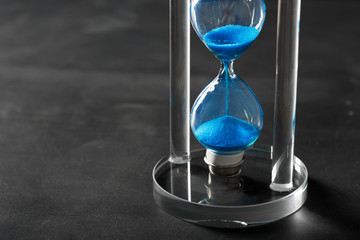 Time is passing. Blue hourglass close up