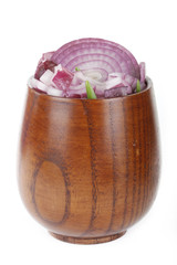 slices of red onion in wooden cup isolated