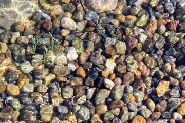 Stones on sea floor under the wave