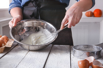 Woman baker stir dough with eggs and flour
