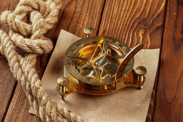 Compass and rope on wooden table. close up