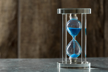 Time is passing. Blue hourglass close up