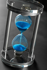 Time is passing. Blue hourglass close up