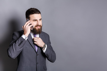 Cheerful bearded businessman talking on phone