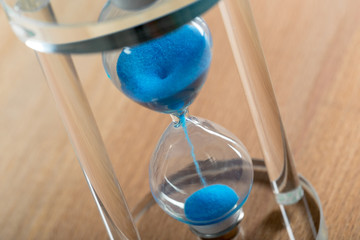 Time is passing. Blue hourglass close up