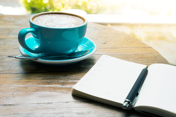 Cup of coffee latte with notepad top view on wooden table/vintage