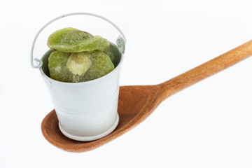 Full bucket of dried kiwi stands in a wooden spoon.