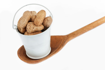 Full bucket of peanut stands in a wooden spoon.