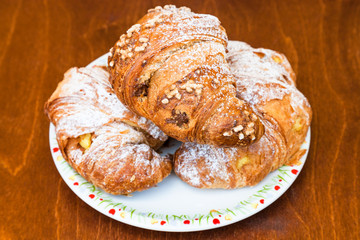 three fresh croissants on table