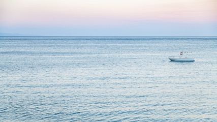 Fototapeta premium view of boat in Ionian sea in summer twilight