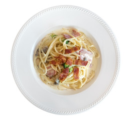 Italian pasta spaghetti carbonara with fried bacon in ceramic plate top view isolated on white background, clipping path included