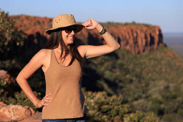 Girl using hat at an african landscape. Waterberg plateau, Namibia
