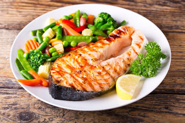 plate of grilled salmon steak with vegetables