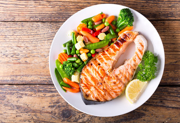 plate of grilled salmon steak with vegetables