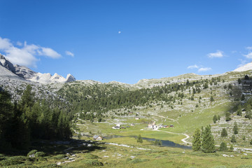Moon rise over valley and dolomite mountains, Italy