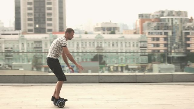 Young man on a hoverboard. Dancing moves on gyroboard. Make friends with technology.