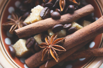 Ingredients for making coffee. Coffee beans, anise, cinnamon sticks, brown sugar in dark ethnic...