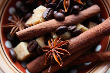 Ingredients for making coffee. Coffee beans, anise, cinnamon sticks, brown sugar in dark ethnic dishes.