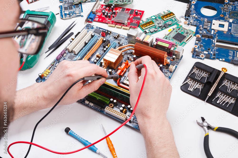 Poster engineer checking motherboard with multimeter