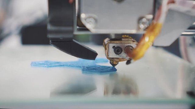 Three dimensional printer during work in school laboratory, 3D plastic printer, 3D printing.