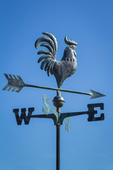 Weather vane showing direction of wind against clear blue sky, vertical