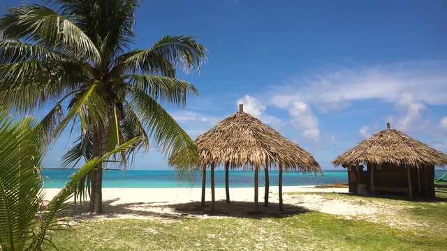 Beach with white sand with beach house on a tropical island Daco. Beautiful sky, sea, resort. Seascape: Ocean and beautiful beach paradise. Philippines. 4K video. Travel concept.