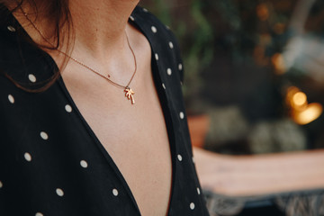 fashion details. woman wearing a black and white polka dot off dress. wearing a small and trendy gold palm tree necklace. ideal summer outfit accessories. european fashion blogger streetstyle. - obrazy, fototapety, plakaty