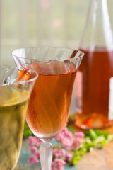 Cold summer wines, white and rose, served in beautiful glasses on terrace in cafe with romantic flowers