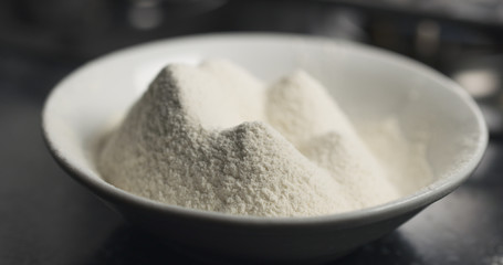 handheld shot of flour in plate on kitchen