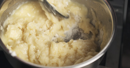 Handheld shot of mixing flour with butter mix for making choux dough