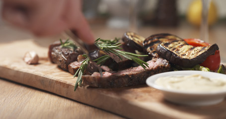 cutting piece from rib eye steak and dip sauce