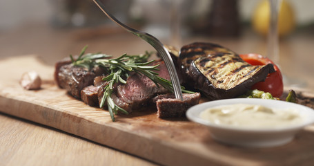 cutting piece from rib eye steak and dip sauce