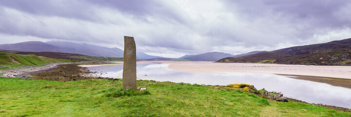 Standing stone with ancient Keltic symbols by the Kyle of Durness at Keoldale, near Durness,...