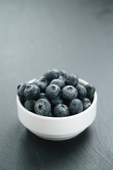 fresh blueberries in white bowl on slate board