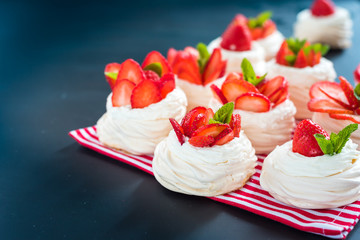 A small meringue Pavlova dessert with some strawberry slices
